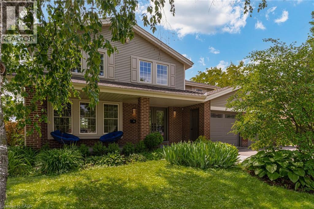 Two-story residence featuring brick and siding facade, covered front porch, and an attached two-car garage