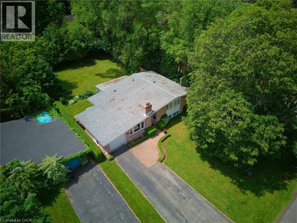 Single-story residence featuring a gray shingle roof, brick facade, and a prominent chimney