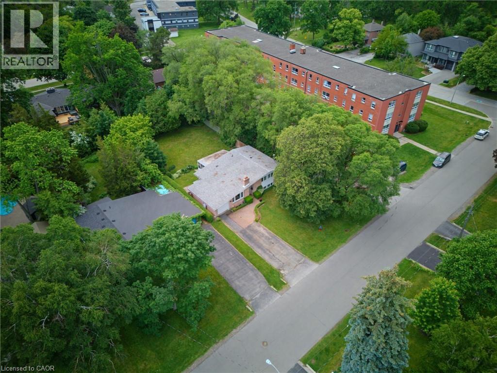 Aerial perspective showcasing a residential property with a shingle roof and a spacious paved driveway