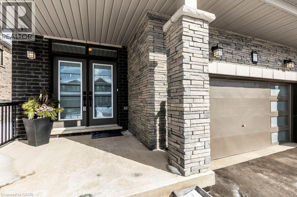 Exterior featuring a stone-clad facade, dark brick accents, and a double-door entry with transom window