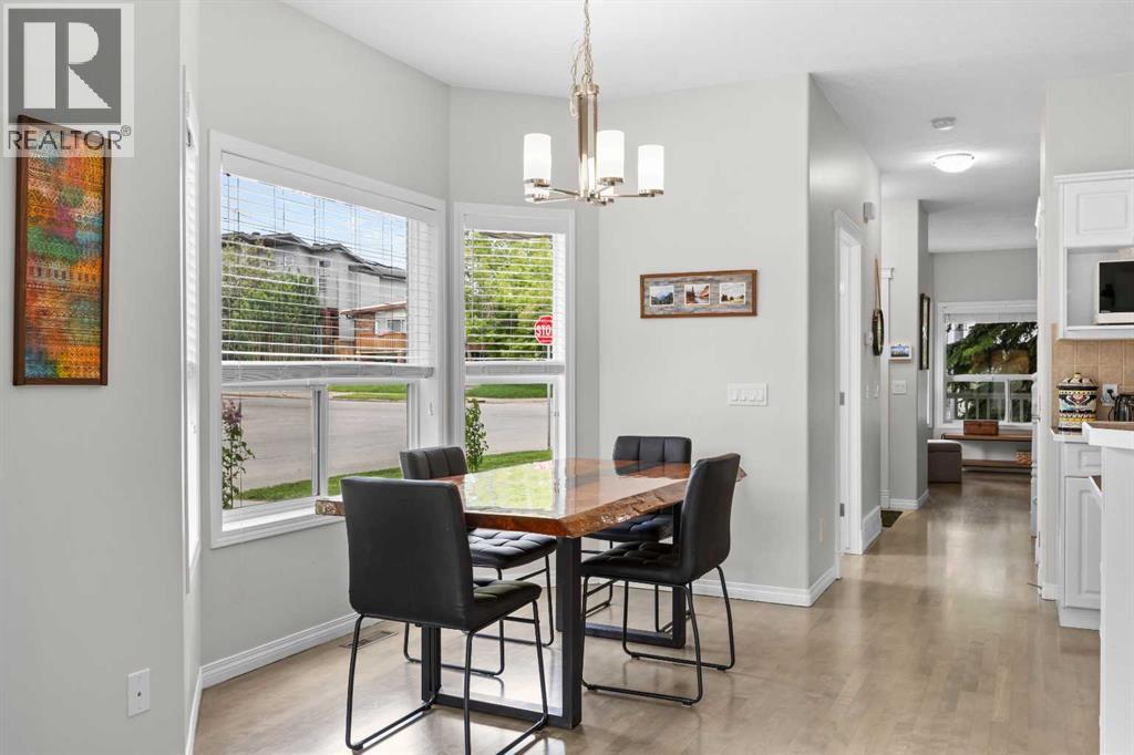 Wide plank flooring and crisp white trim carry the eye down the hall, connecting the dining space to the front of the home