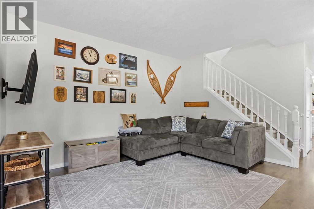 The family room connects to the upper level via a bright staircase with classic white spindle railings