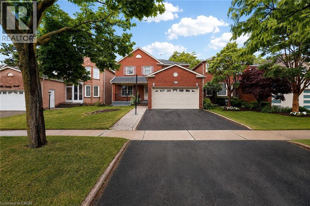 Brick exterior residence featuring an attached two-car garage with a white panel door