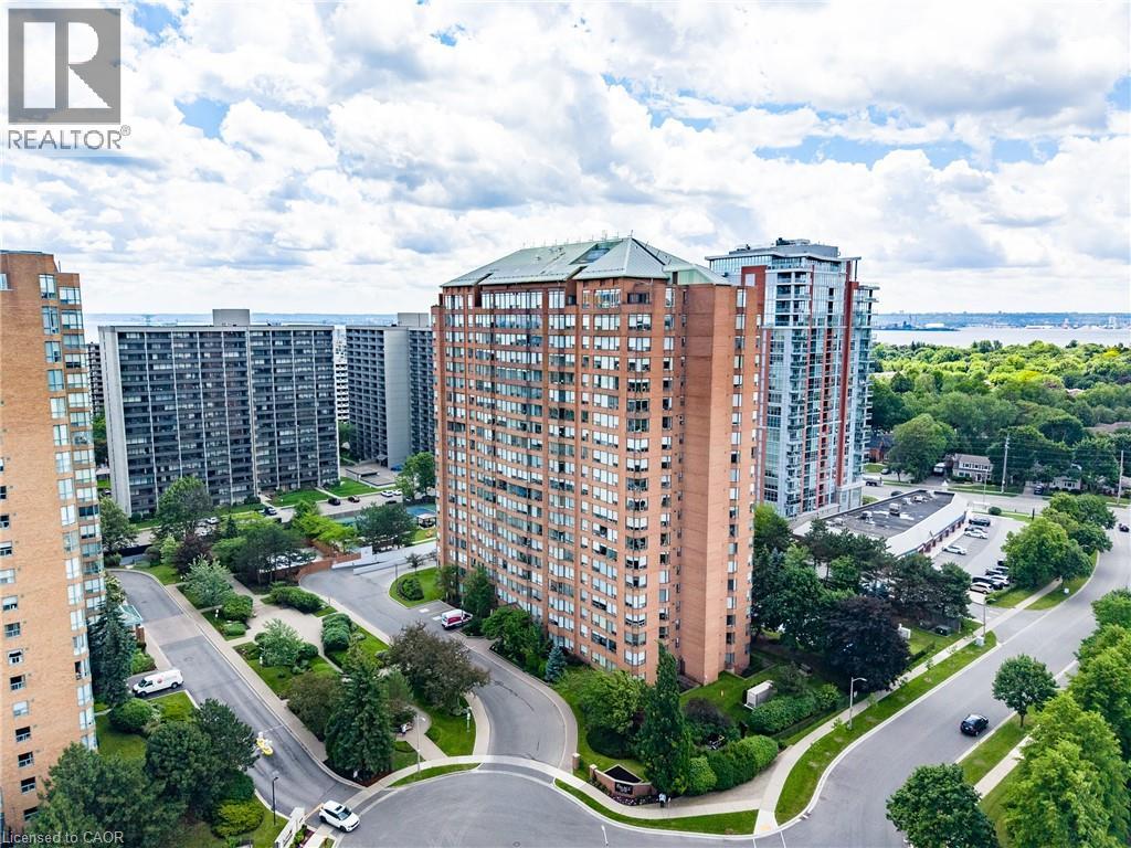 Brick high-rise building featuring multiple balconies and a peaked roof