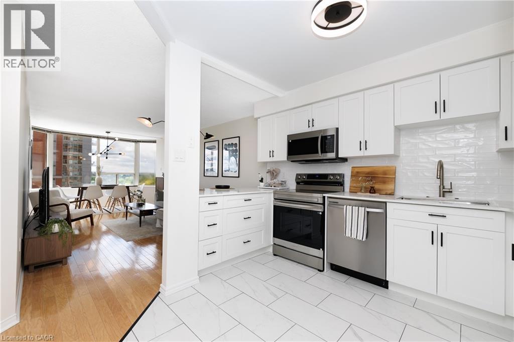Modern kitchen featuring white shaker cabinetry, stainless steel appliances, and a white subway tile backsplash