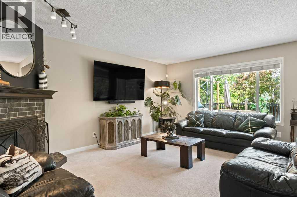 Warm and inviting main floor living room featuring a cozy gas fireplace and large rear facing window