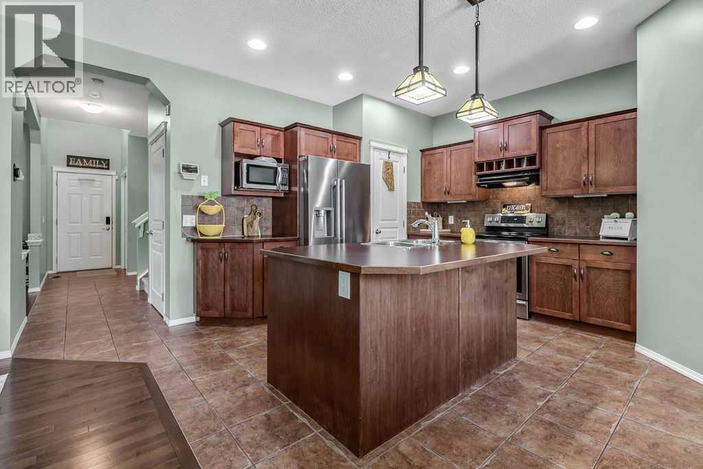 Rich maple cabinetry, expansive counter space, a large centre island, and a corner pantry make this kitchen as functional as it is inviting