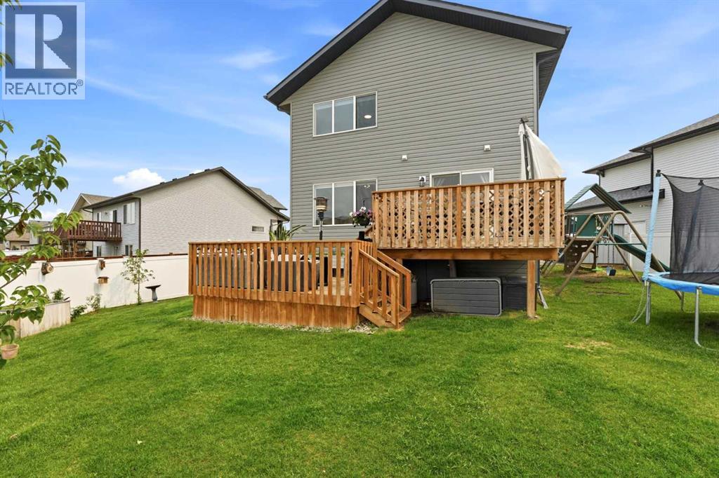 Outside, enjoy the two-tier deck, fire pit area, included storage shed and play structure, vinyl fencing, and plenty of room for kids and pets to play thanks to the oversized pie-shaped backyard
