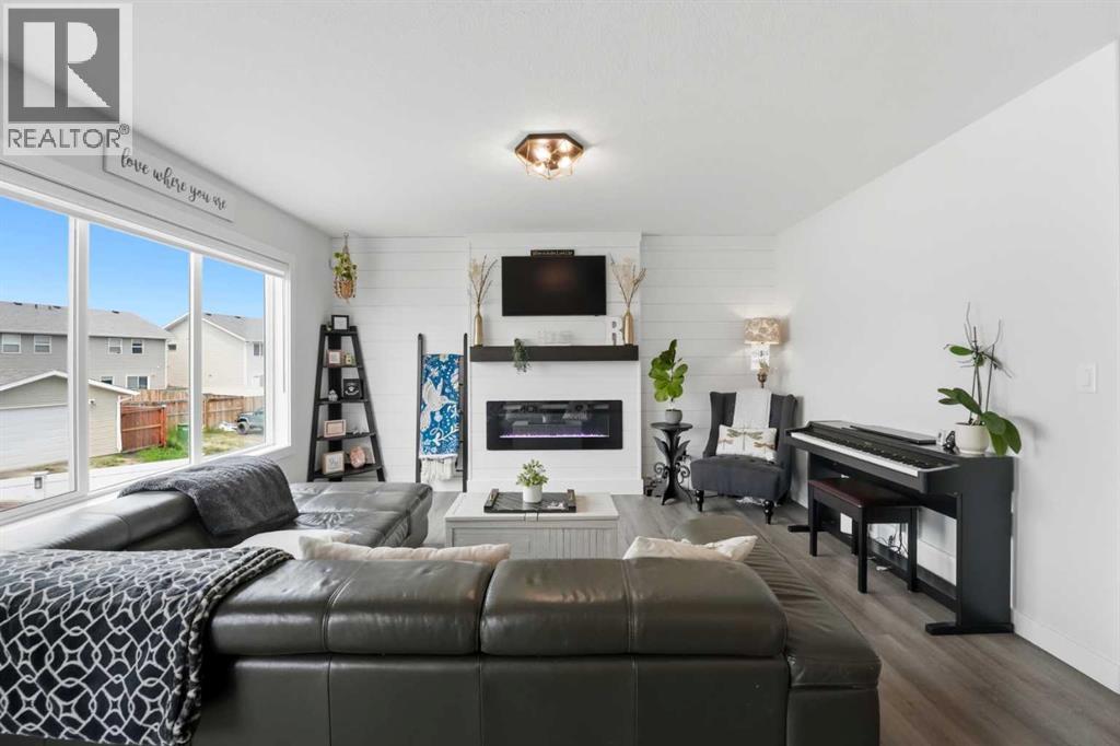 The inviting living room features a stunning shiplap style feature wall with an electric fireplace
