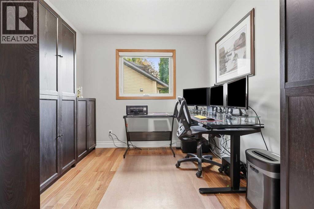 MAIN FLOOR OFFICE/DEN - easy care hardwood flooring and lots of storage make this office perfect for any work from home scenario