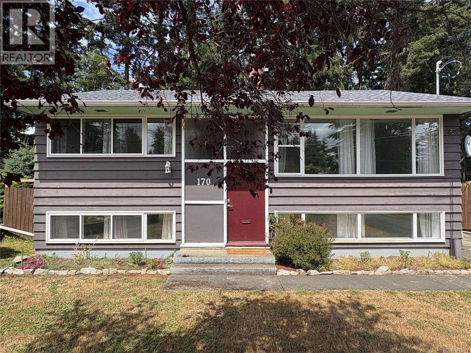 Split-level residence featuring a dark gray shingle roof and horizontal wood siding