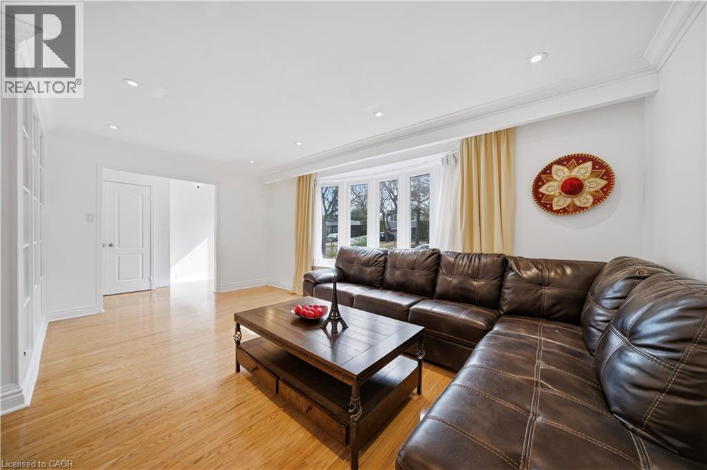 Spacious living area featuring light wood-finish flooring, recessed lighting, and crown molding