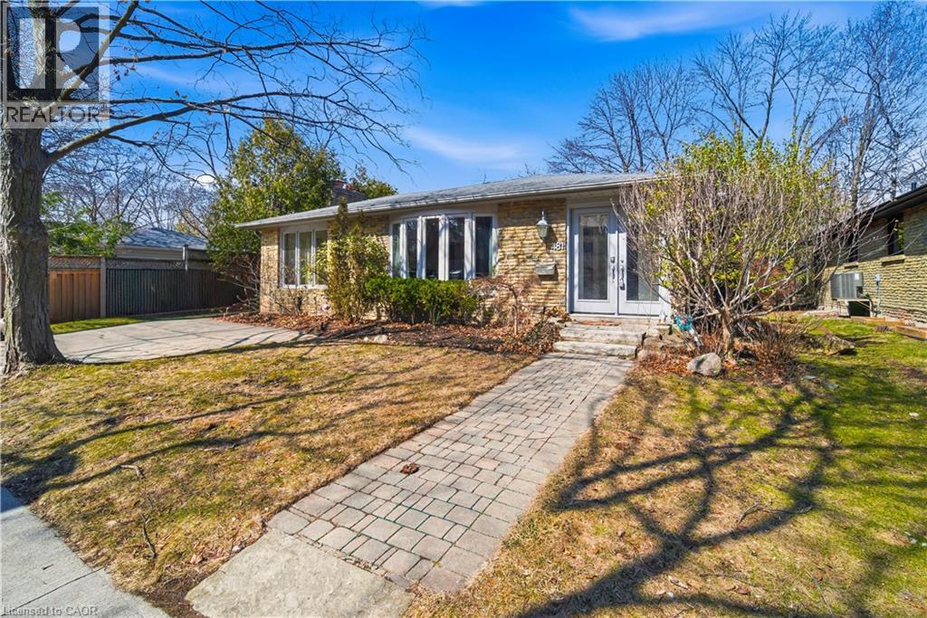 Traditional-style home featuring a brick facade, bay window, and a paver stone walkway leading to French entry doors