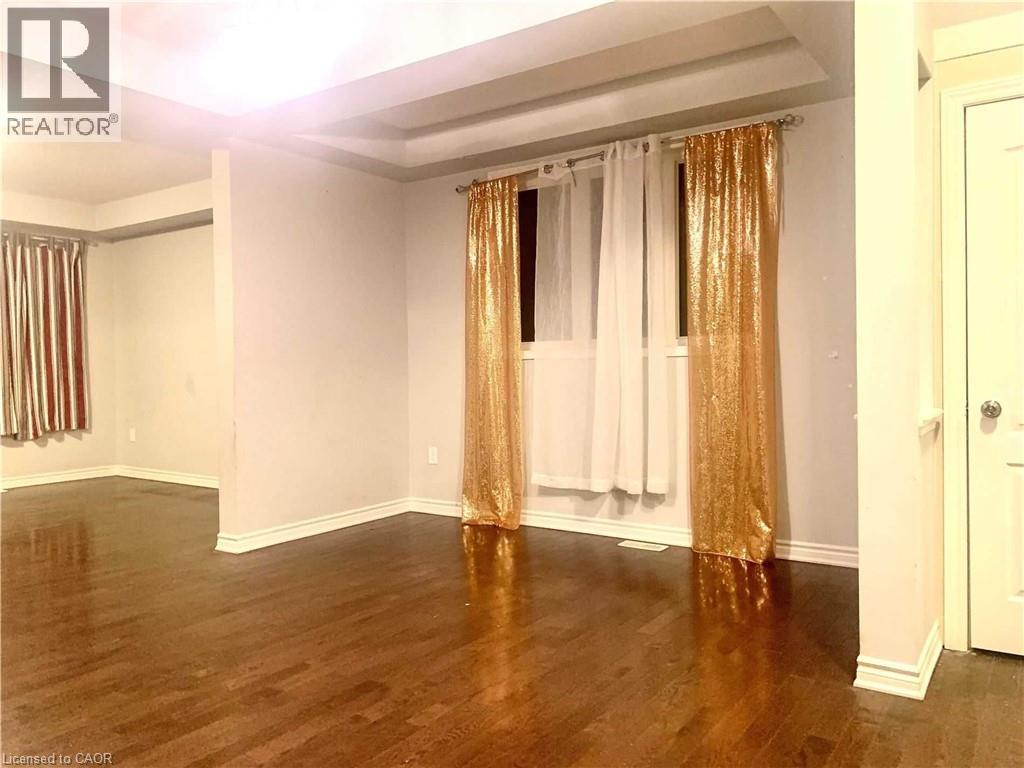 Hardwood flooring throughout, featuring a tray ceiling and white baseboards