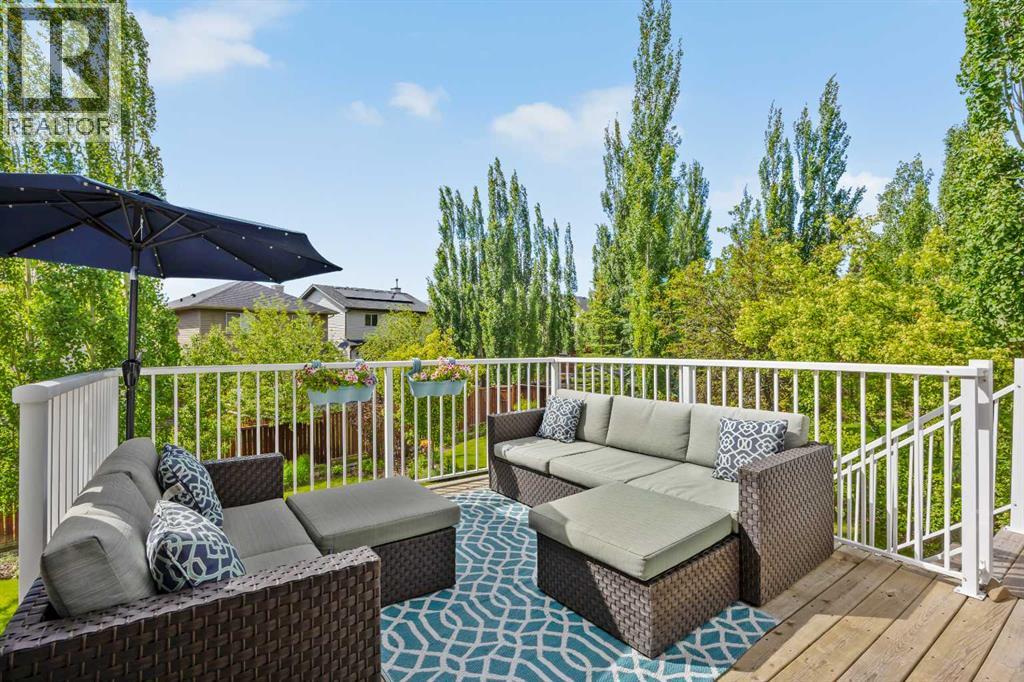 The upper deck overlooks all that backyard greenery — already set up for morning coffees, evening wind-downs, and the kind of nights that run longer than planned