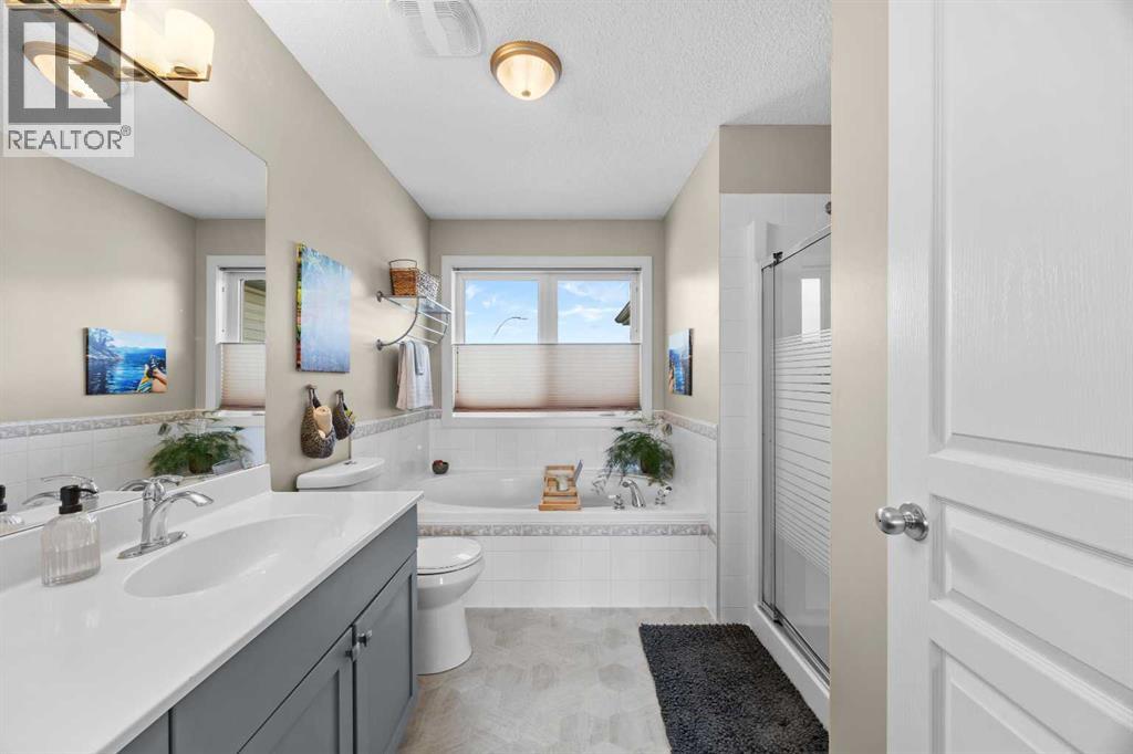 The 4-piece ensuite delivers the best of both worlds — a deep soaker tub beneath the window and a separate stand-up shower for the mornings that move fast