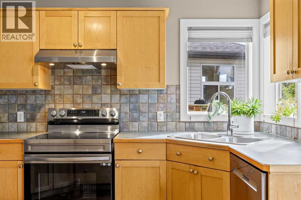 Stainless steel appliances, a tile backsplash with character, and a sunny window over the sink — the little things that make the everyday routine feel a bit brighter
