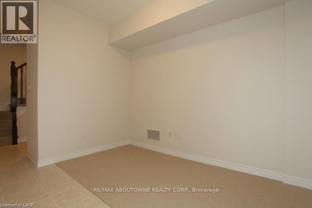 Carpeted room with neutral wall tones and white baseboards