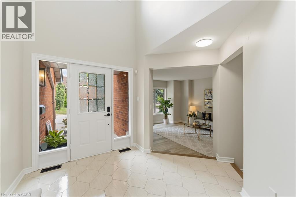Entryway featuring white hexagonal floor tiles, a white paneled door with frosted glass inserts, and transom windows