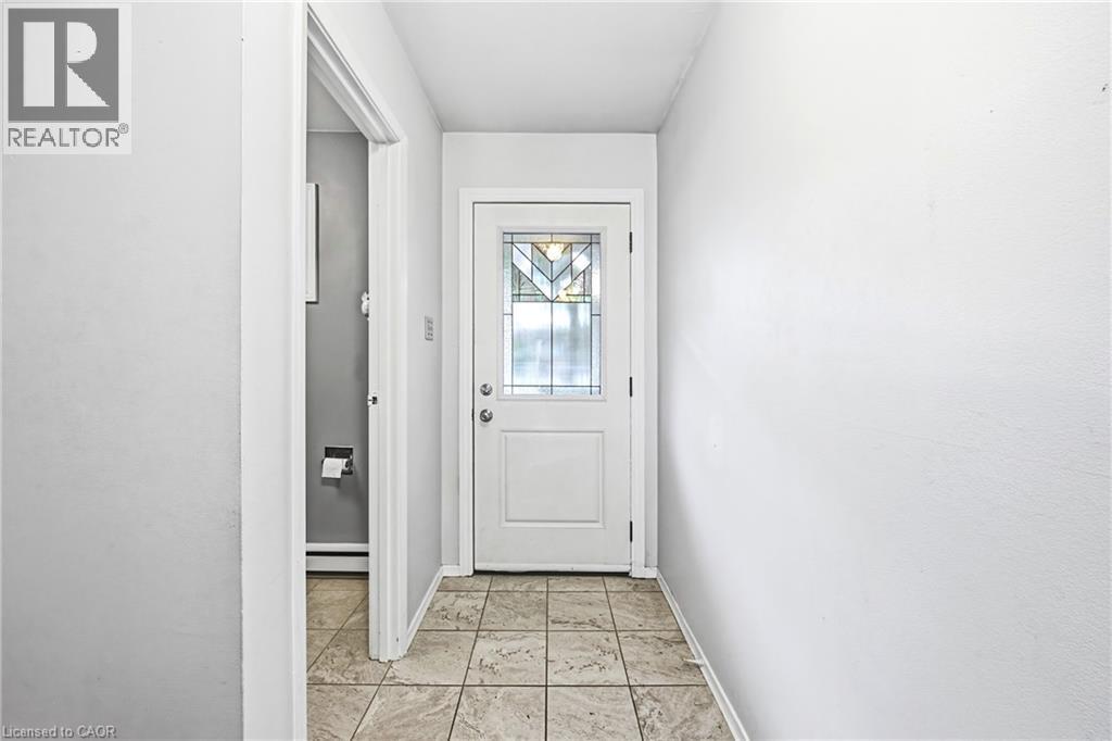 Entryway featuring a white paneled door with decorative glass inserts and light-toned square floor tiles