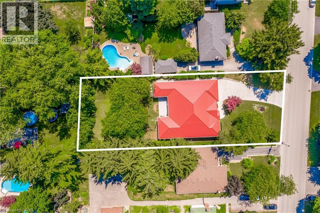 Property featuring a red tile roof, concrete driveway, and mature landscaping
