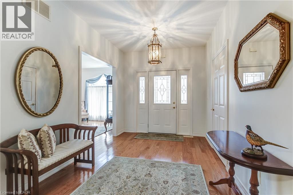 Entryway featuring a decorative transom and sidelight windows, a hanging lantern-style light fixture, and wood-finish flooring