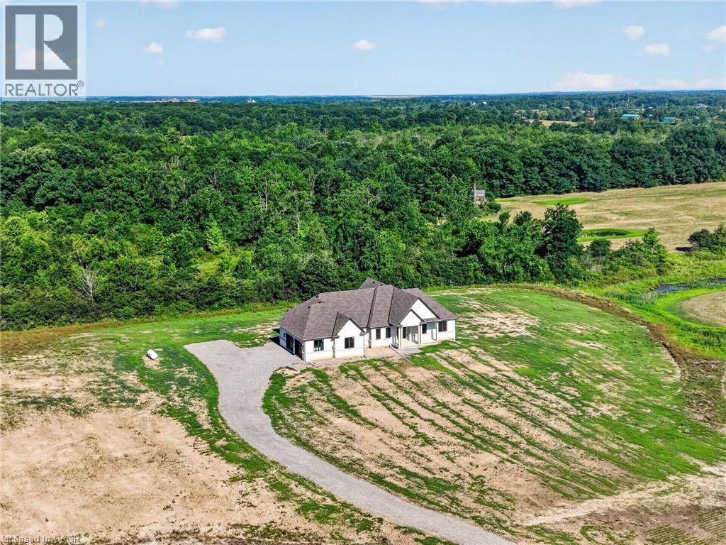 Single-story residence situated on a graded lot, featuring a gravel driveway and a dark shingle roof