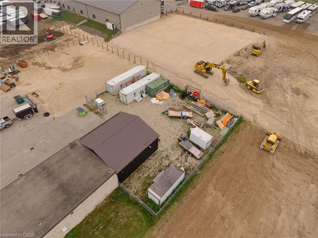 Expansive undeveloped land featuring a cleared, level section, visible construction equipment, and partial perimeter fencing