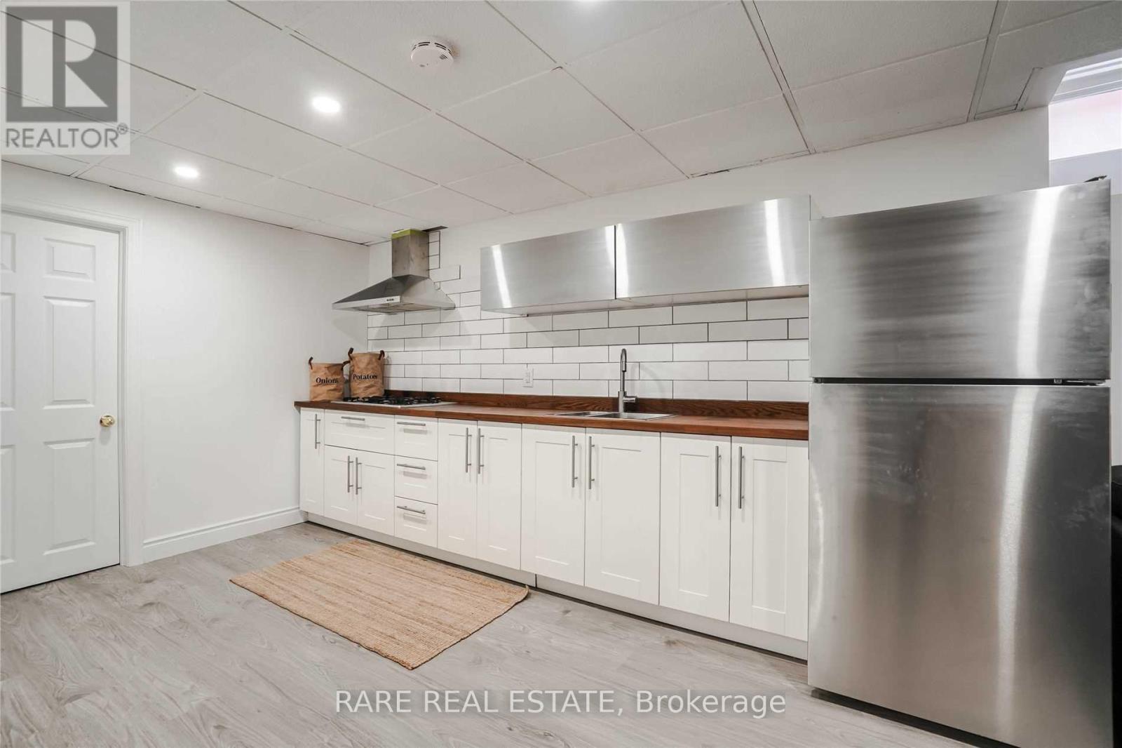 Modern kitchen with stove top/range, sink, fridge.