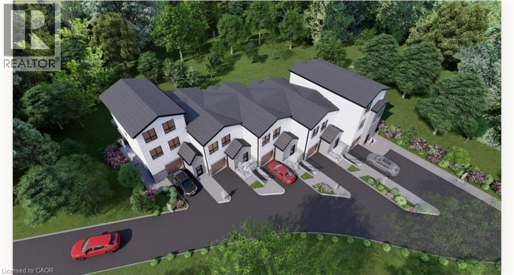 Modern townhouse development featuring individual garages, private driveways, dark grey roofs, white siding, and mature surrounding trees