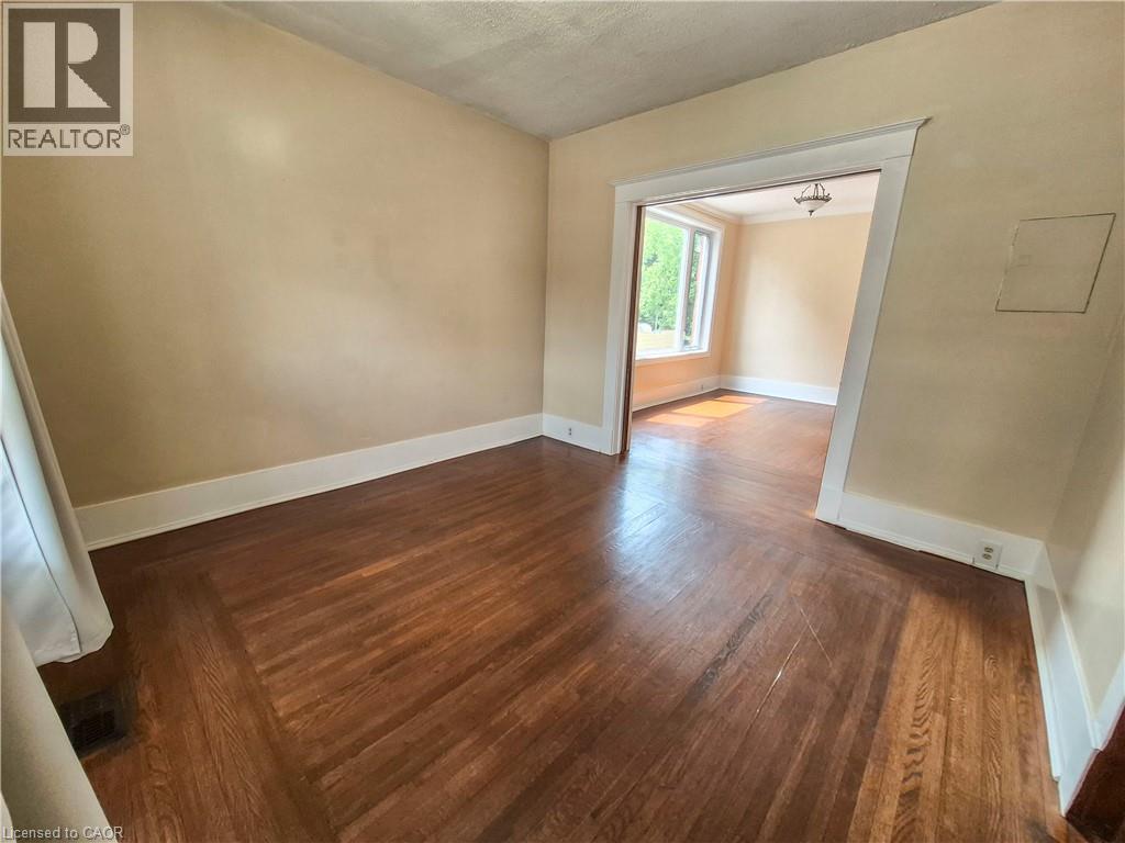 Hardwood flooring with a decorative border design, neutral wall tones, and white trim throughout