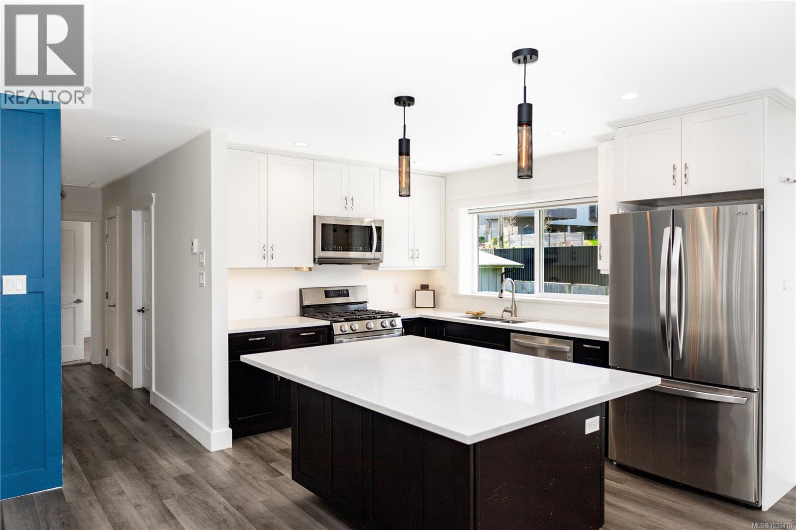This is the upstairs kitchen. Both kitchens have quartz counters with stainless appliances. Both up and down have open concept designs.
