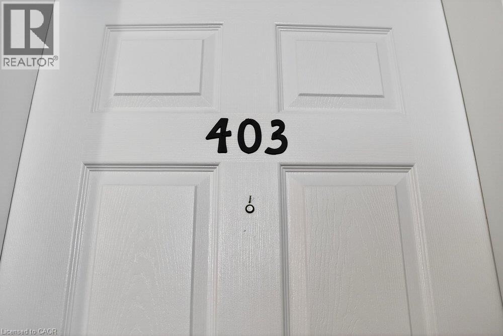 Panel-style entry door with a white finish, featuring black numerical designation and a peephole fixture