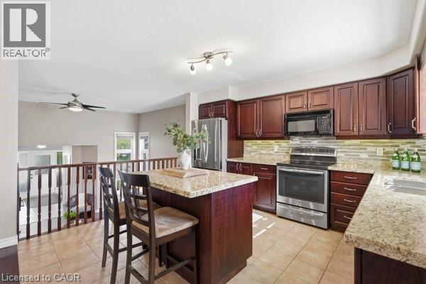 Kitchen featuring dark wood cabinetry, stainless steel appliances, and light granite countertops