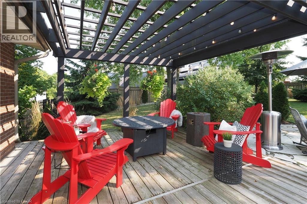 Expansive wood-finish deck with a dark-stained pergola featuring string lighting