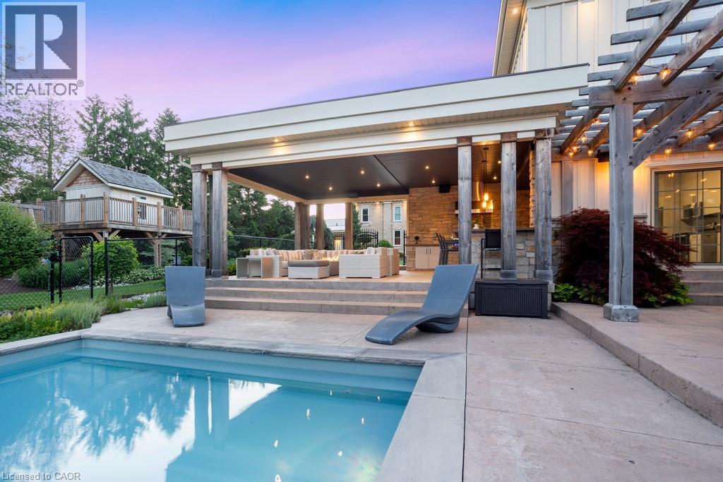 In-ground swimming pool with an expansive concrete patio and a multi-level outdoor living area