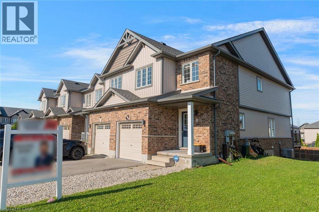Contemporary townhome featuring a brick and siding exterior, an attached garage, and a covered front entry