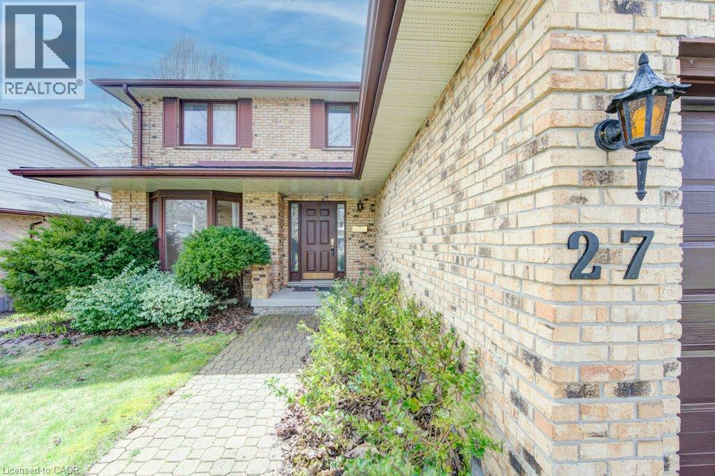 Brick exterior featuring a bay window, dark brown front door, and a paver walkway