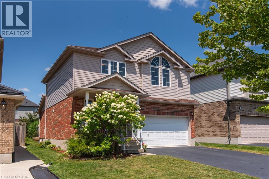 Two-story home featuring a brick and vinyl exterior with a peaked roofline and gabled entry