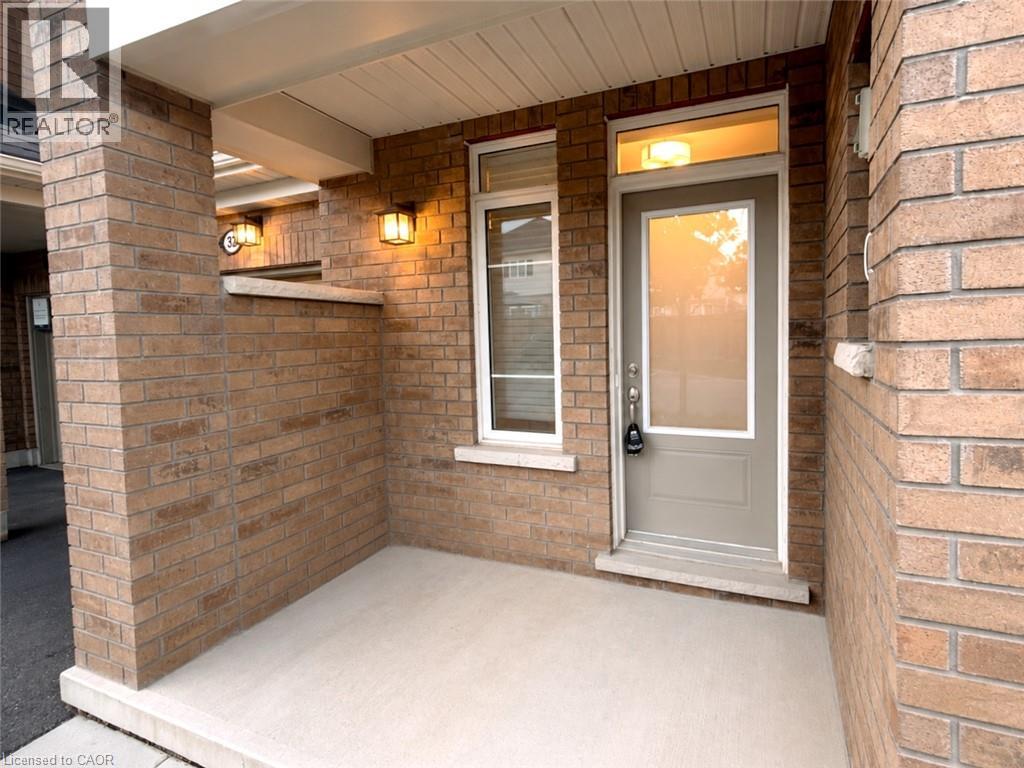 Brick exterior with a covered entry, transom window, and exterior wall sconces