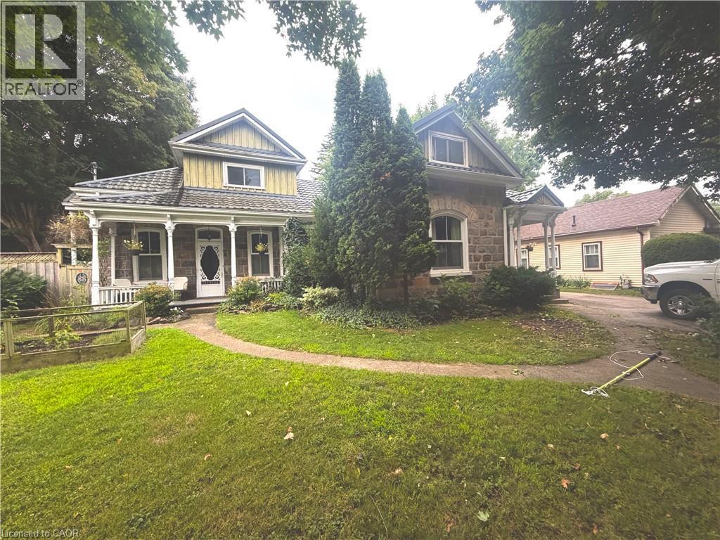 Stone and siding exterior with a covered front porch featuring decorative columns