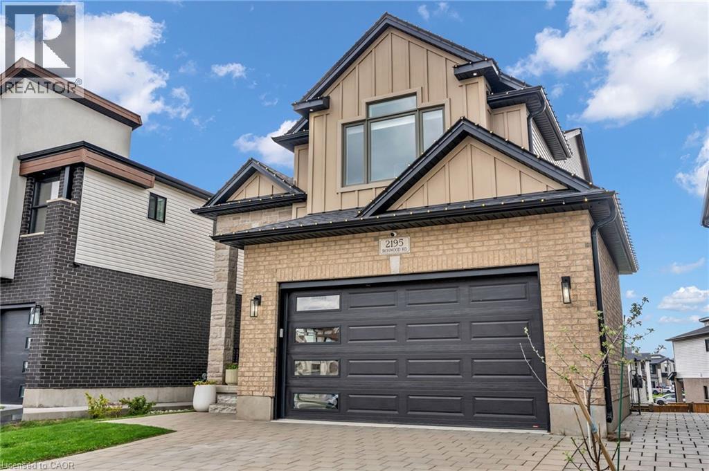 Contemporary exterior featuring a two-car garage with frosted glass inserts, light brick facade, and dark roofline