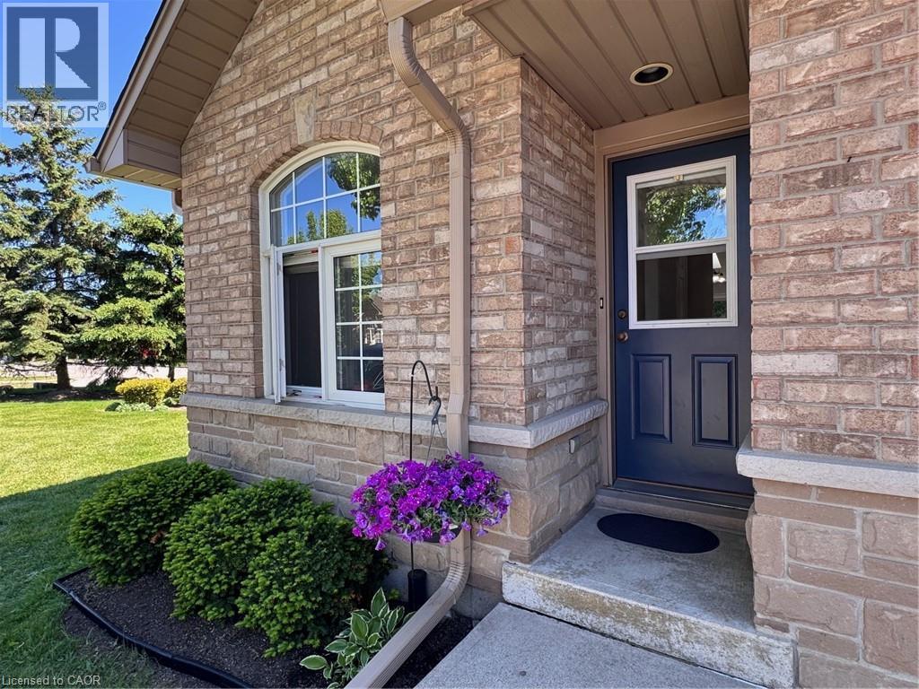 Brick and stone exterior featuring a dark blue entry door with an upper window