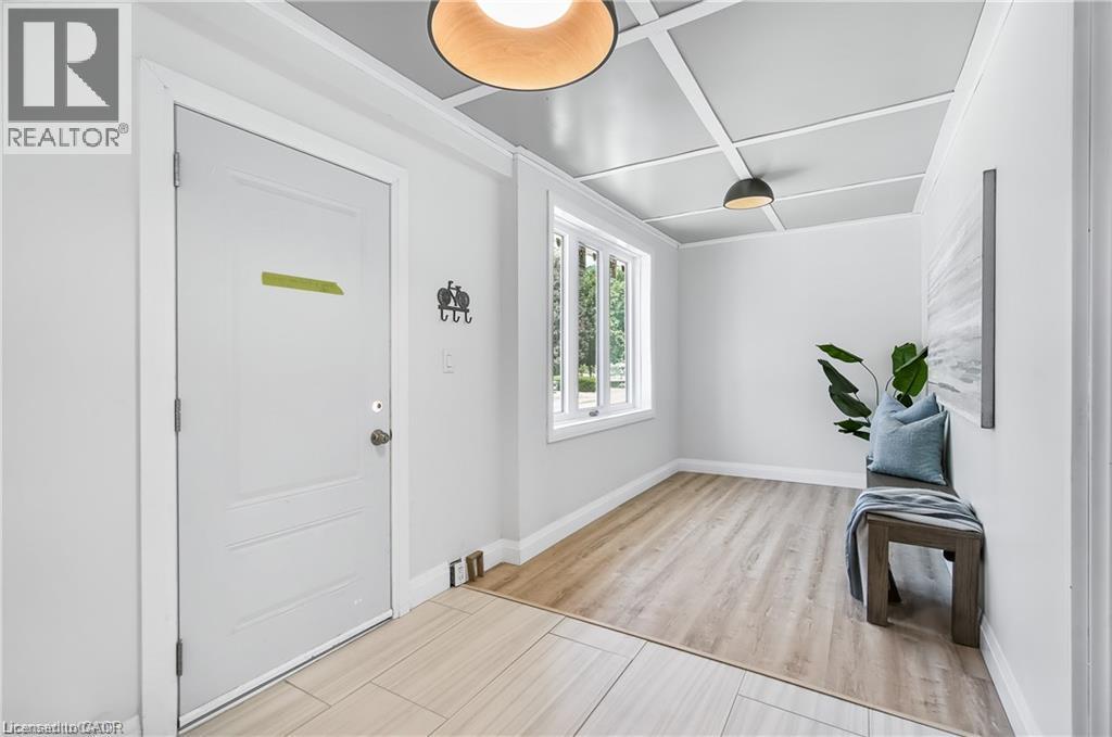 Entryway featuring a coffered ceiling with recessed lighting, large window, wood-finish flooring, and white interior walls