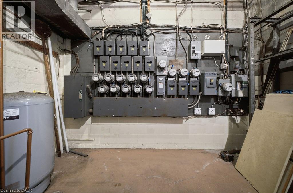 Utility area featuring multiple electrical meters and conduit, a water heater with copper plumbing, and exposed ductwork