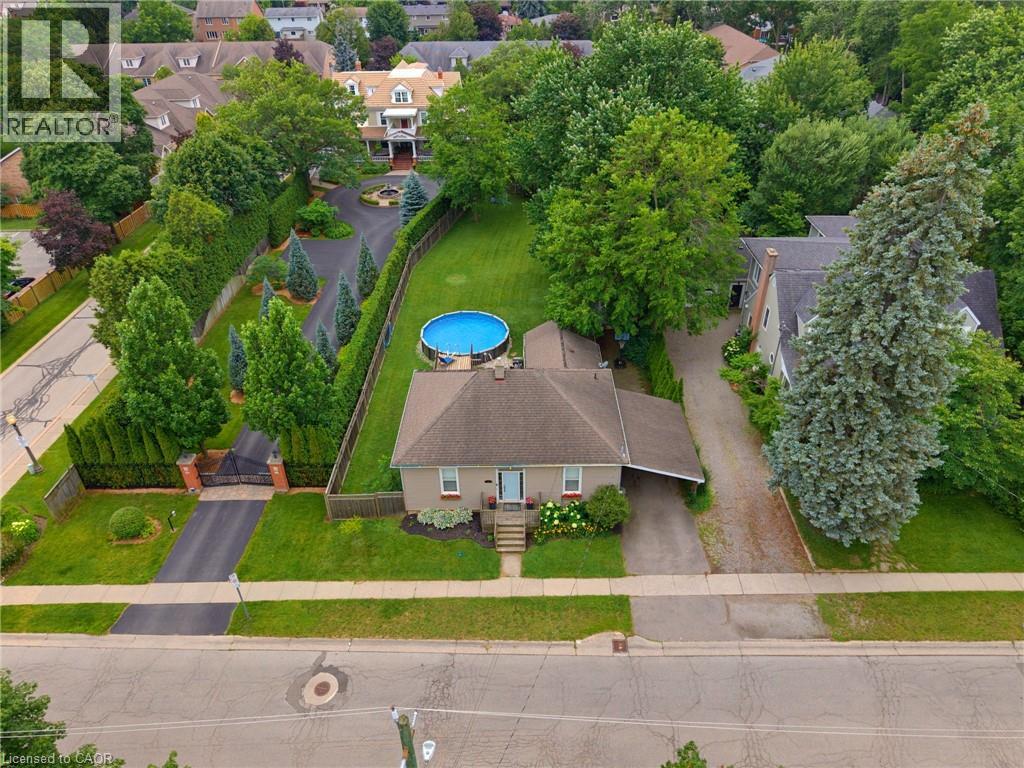 Property featuring a private driveway, mature landscaping, and an expansive grassy yard