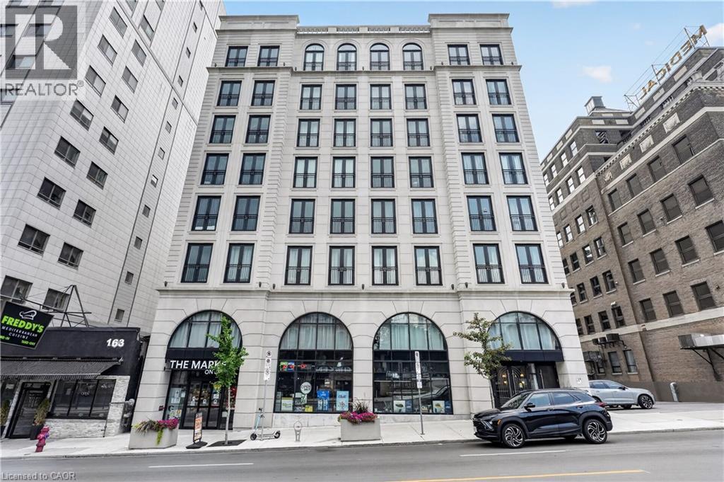 Multi-story facade featuring arched ground-level windows and distinct fenestration patterns