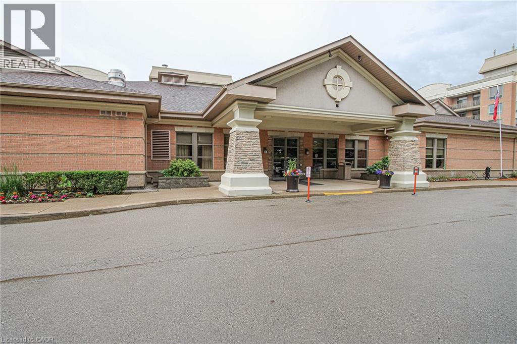 Brick exterior featuring a gabled portico entrance with stone-clad columns, large windows, and a dark shingle roof