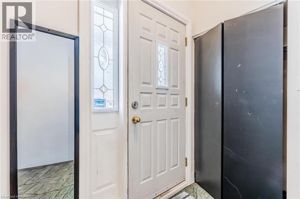 Entryway featuring a white door with decorative glass inserts, a coordinating sidelight, and a built-in closet with dark bifold doors