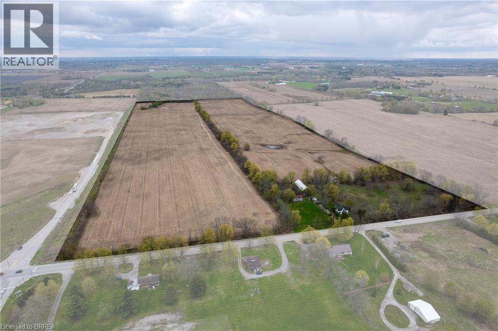 Expansive agricultural land featuring a primary residence, multiple outbuildings, and cultivated fields